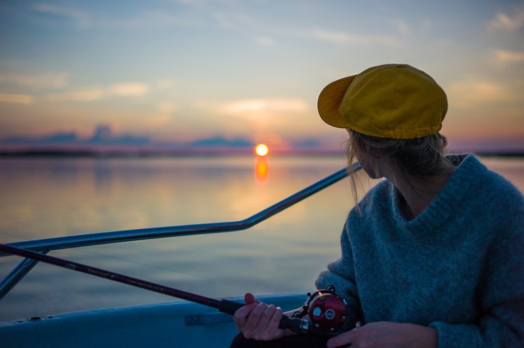 woman fishing looking at sunset