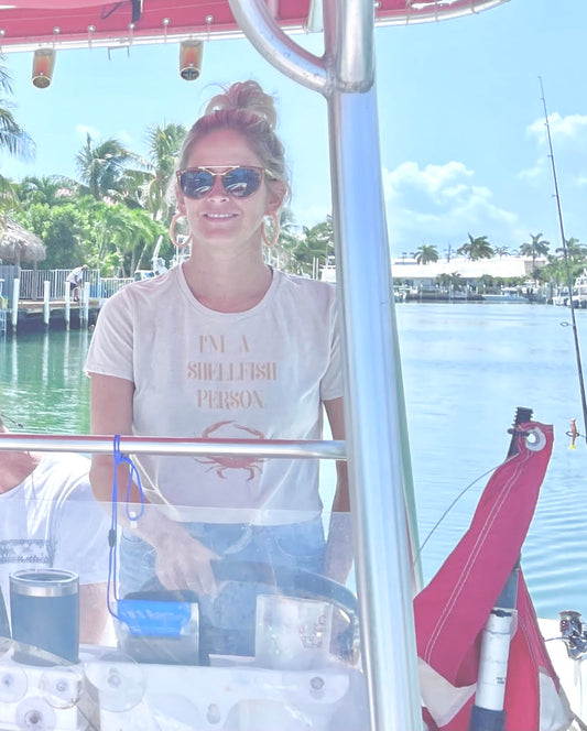 woman wearing i'm a shellfish person cropped tee on boat — seek outdoors
